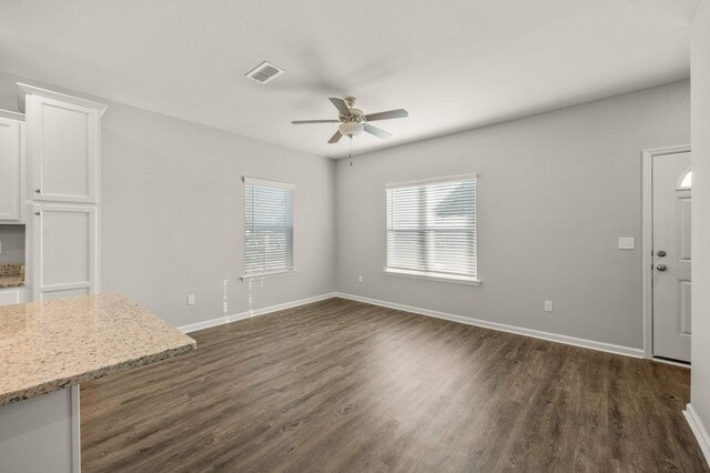 unfurnished living room featuring dark hardwood / wood-style flooring and ceiling fan