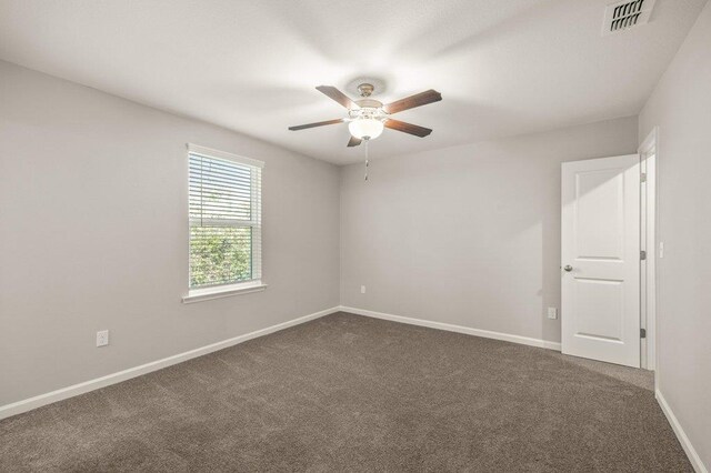 carpeted spare room with ceiling fan