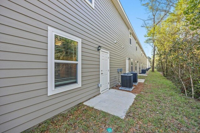 exterior space with a lawn and central AC