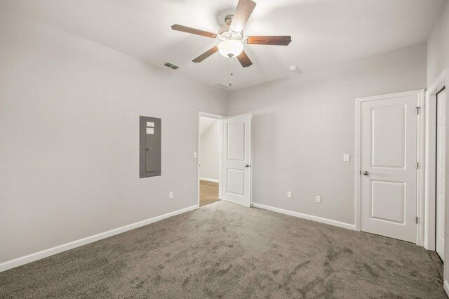 unfurnished bedroom with electric panel, ceiling fan, and carpet floors