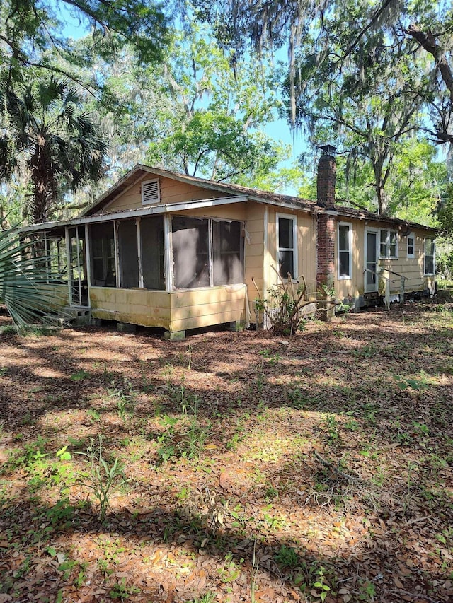 1618 Golf Course Rd, Perry, FL 32347 - view of side of home with a sunroom and a chimney
