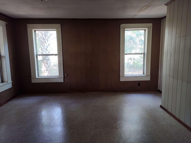 spare room featuring wooden walls