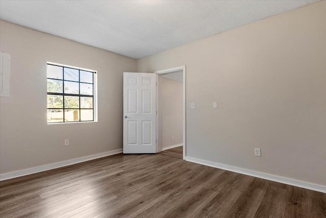 empty room with wood-type flooring and a textured ceiling