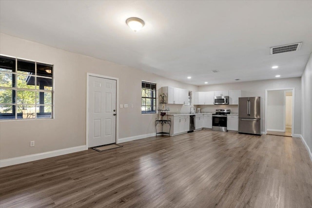 unfurnished living room featuring sink and dark wood-type flooring