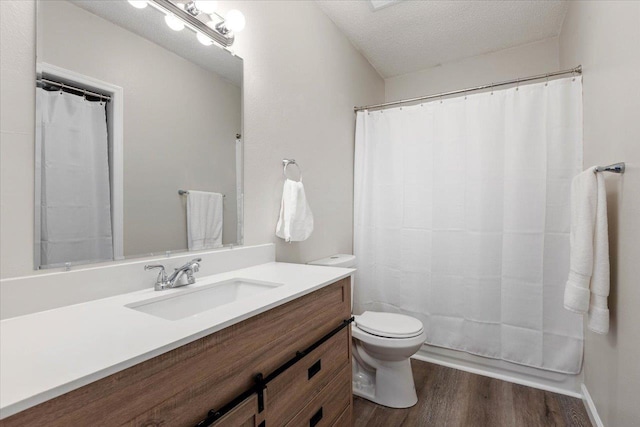 bathroom with vanity, hardwood / wood-style flooring, a shower with shower curtain, toilet, and a textured ceiling