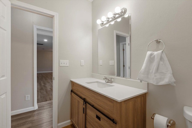 bathroom with vanity, hardwood / wood-style flooring, and toilet