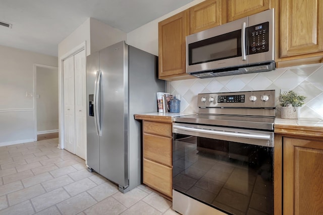 3508 Willow Springs Ln, Tallahassee, FL 32312 - kitchen featuring appliances with stainless steel finishes, decorative backsplash, and light tile patterned floors