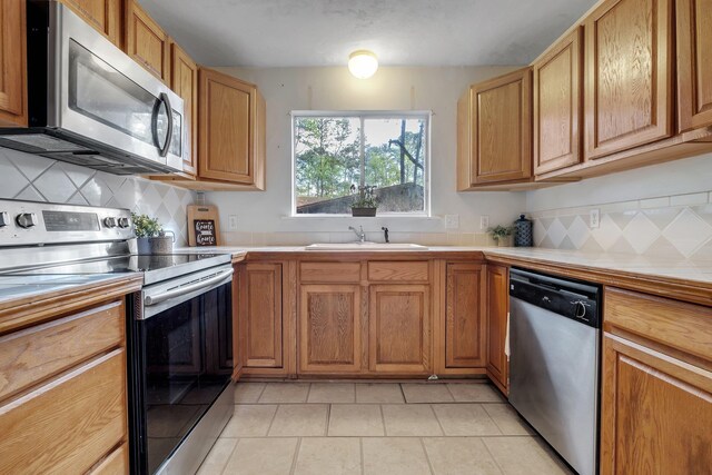 3508 Willow Springs Ln, Tallahassee, FL 32312 - kitchen featuring appliances with stainless steel finishes, tile countertops, decorative backsplash, and light tile patterned flooring