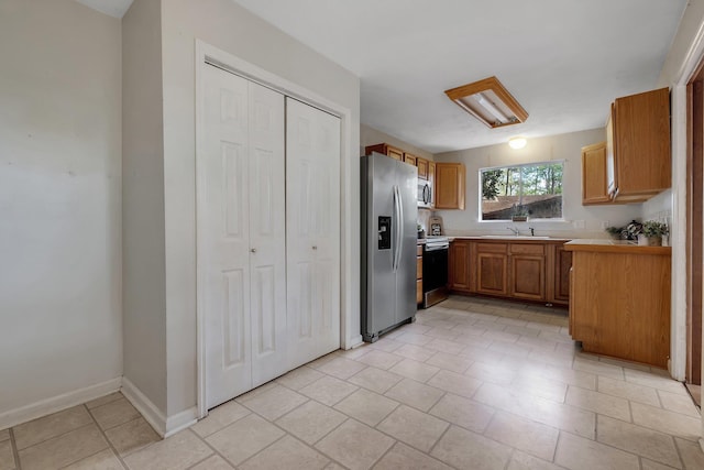 3508 Willow Springs Ln, Tallahassee, FL 32312 - kitchen with appliances with stainless steel finishes, light countertops, brown cabinets, and light tile patterned floors