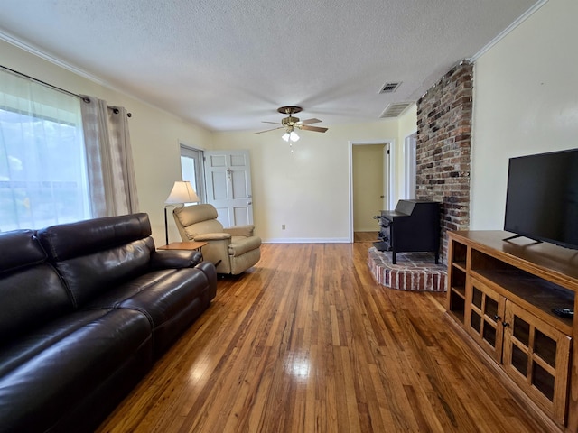 2612 W Tharpe St, Tallahassee, FL 32303 - living area featuring hardwood / wood-style floors, a wood stove, a textured ceiling, a ceiling fan, and ornamental molding