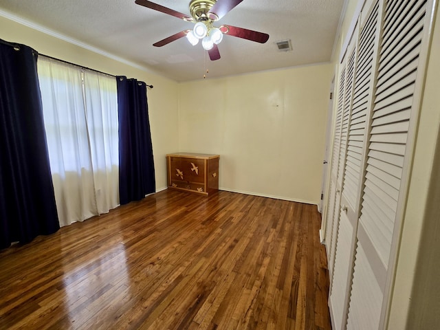 2612 W Tharpe St, Tallahassee, FL 32303 - unfurnished bedroom with wood finished floors, a closet, a textured ceiling, crown molding, and a ceiling fan