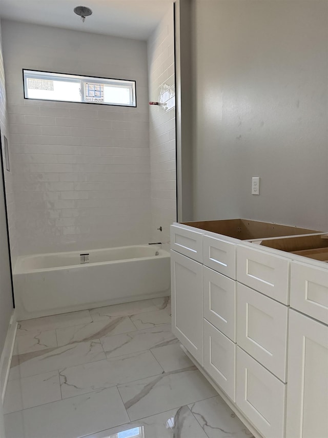 bathroom with marble finish floor, vanity, and washtub / shower combination