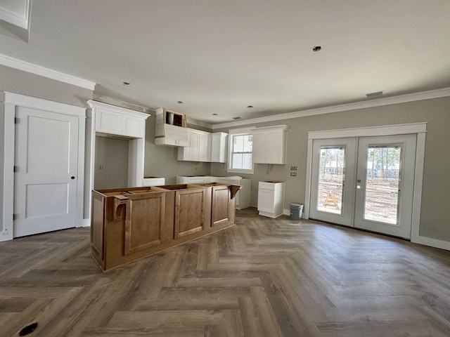 kitchen featuring crown molding, french doors, a kitchen island, and white cabinets