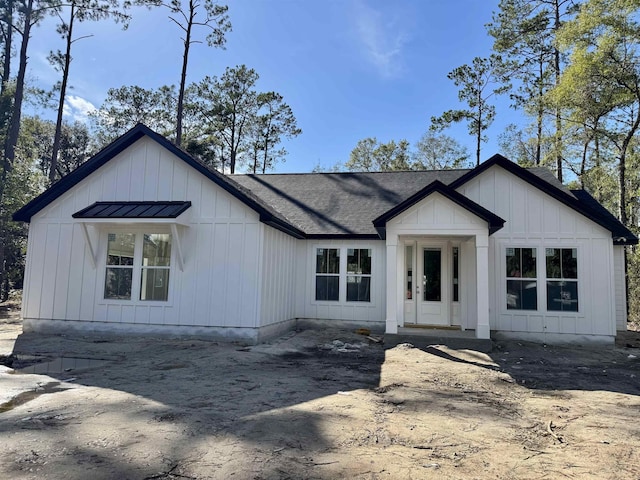 modern inspired farmhouse with roof with shingles and board and batten siding