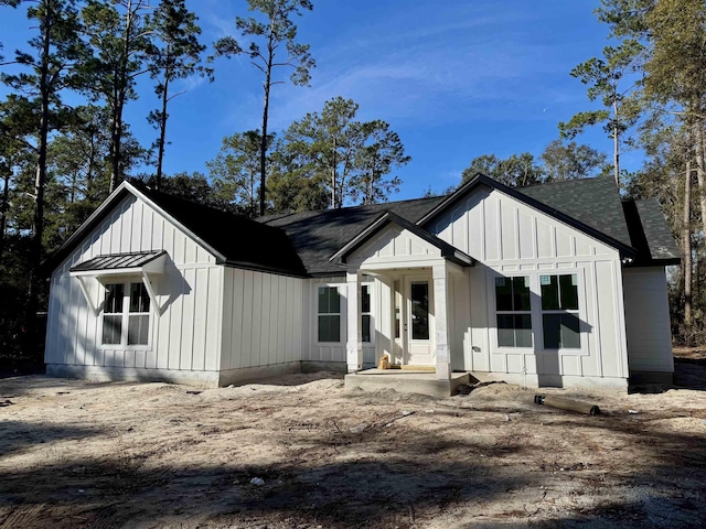 modern inspired farmhouse with a standing seam roof, metal roof, and board and batten siding