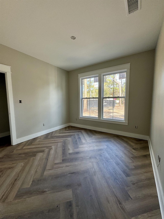 spare room with baseboards and visible vents