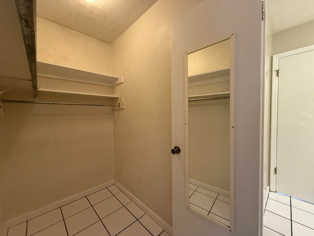 walk in closet with light tile patterned floors