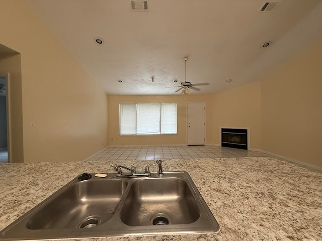 kitchen with light tile patterned flooring, ceiling fan, and sink