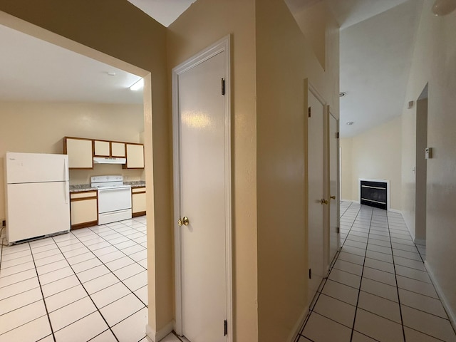 hall with vaulted ceiling and light tile patterned flooring