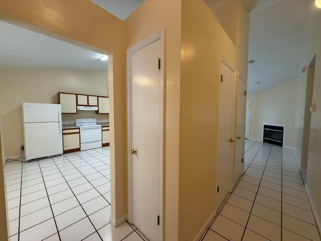 corridor featuring light tile patterned flooring and lofted ceiling