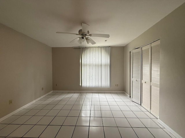 unfurnished bedroom featuring ceiling fan, light tile patterned floors, and a closet