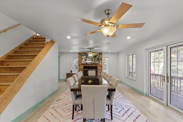 1334 Jr Howell Rd, Steinhatchee, FL 32359 - dining space with stairs, ceiling fan, light wood finished floors, a fireplace, and baseboards