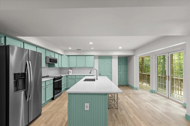 1334 Jr Howell Rd, Steinhatchee, FL 32359 - kitchen featuring stainless steel appliances, a sink, light wood-type flooring, baseboards, and an island with sink