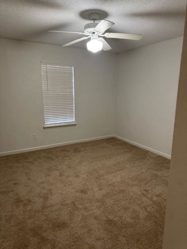 carpeted empty room with ceiling fan and a textured ceiling