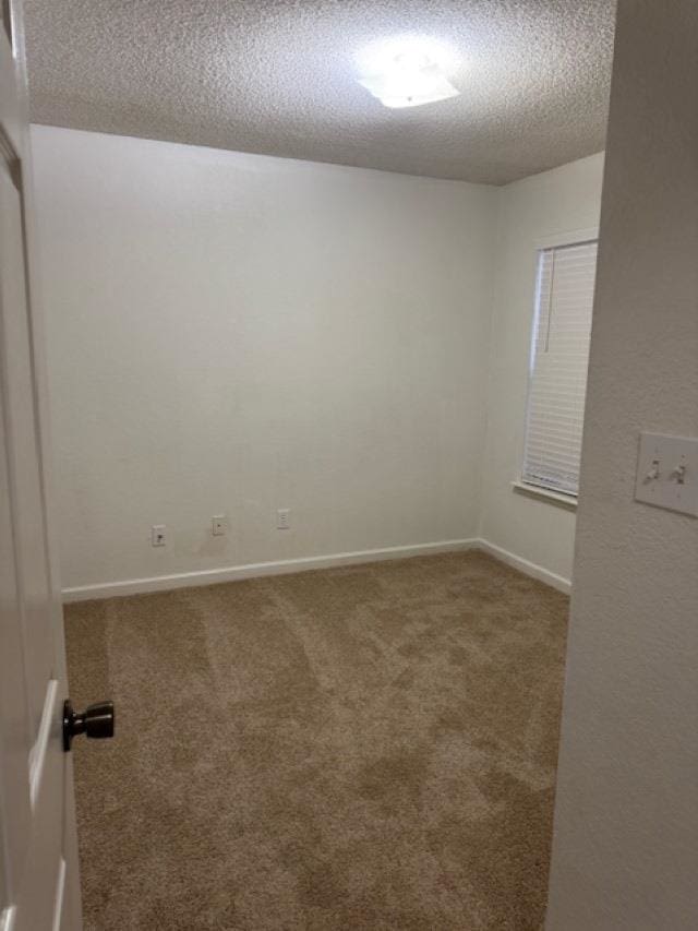 spare room with carpet floors and a textured ceiling