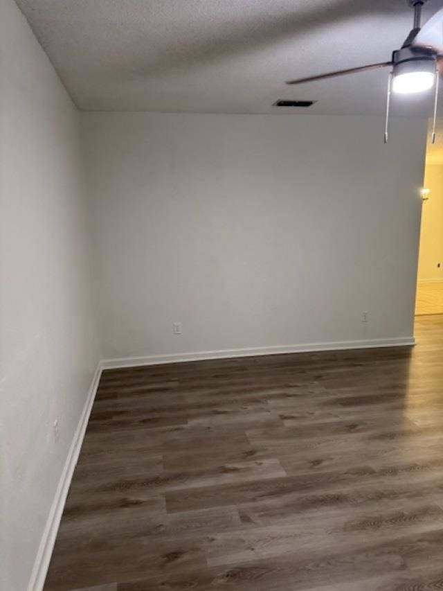 unfurnished room featuring a textured ceiling, dark hardwood / wood-style floors, and ceiling fan