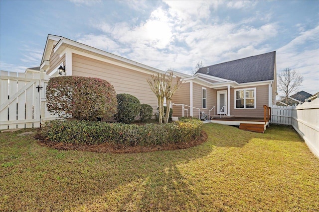 view of home's exterior featuring fence private yard, a gate, and a lawn