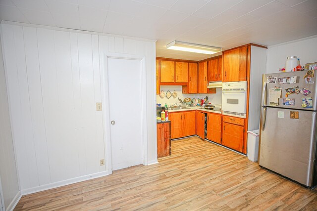 1315 S Center St Unit 1, Perry, FL 32348 - kitchen with freestanding refrigerator, white oven, light wood-style flooring, and brown cabinetry