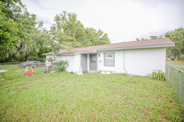 1315 S Center St Unit 1, Perry, FL 32348 - back of house with a fenced backyard, concrete block siding, and roof with shingles
