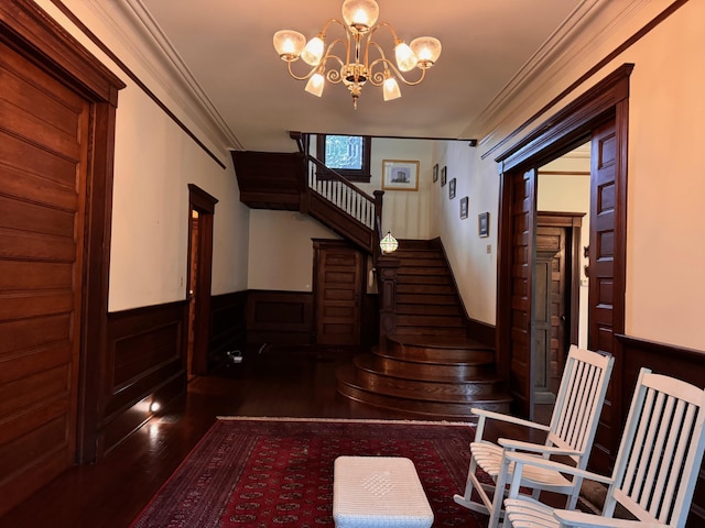 stairway featuring hardwood / wood-style flooring, ornamental molding, and a chandelier