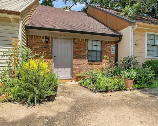 924 S Lipona Rd, Tallahassee, FL 32304 - view of exterior entry with a shingled roof and brick siding