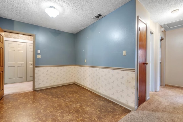820 Essex Dr, Tallahassee, FL 32304 - unfurnished room featuring a textured ceiling, baseboards, wainscoting, and wallpapered walls