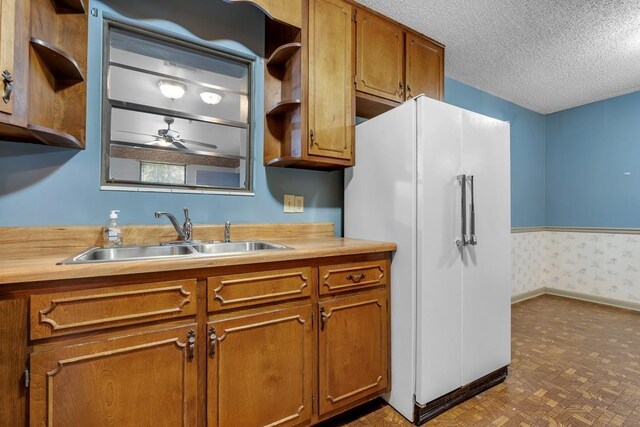 820 Essex Dr, Tallahassee, FL 32304 - kitchen featuring freestanding refrigerator, a sink, open shelves, brown cabinetry, and light countertops