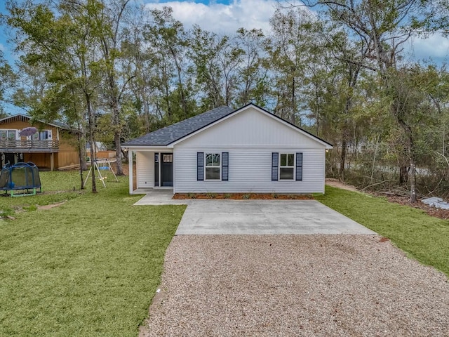 view of front of property with a trampoline and a front lawn