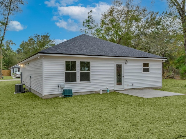 back of house featuring central AC unit, a patio area, and a lawn