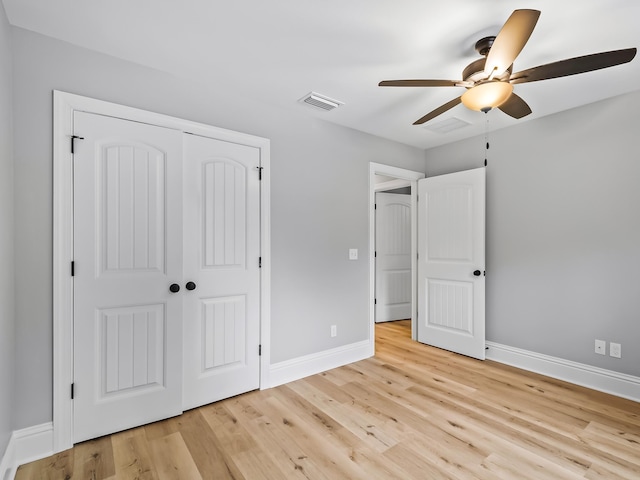 unfurnished bedroom with ceiling fan, light wood-type flooring, and a closet