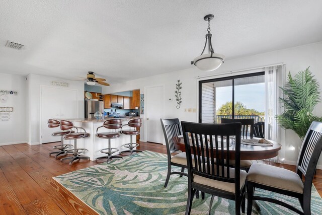 126 Royster Dr, Crawfordville, FL 32327 - dining space with ceiling fan, wood finished floors, a textured ceiling, and baseboards