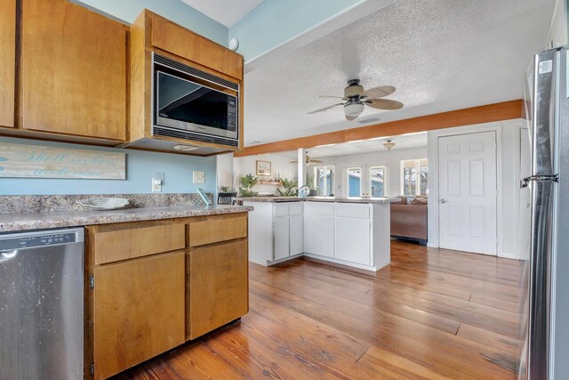 126 Royster Dr, Crawfordville, FL 32327 - kitchen with stainless steel appliances, ceiling fan, open floor plan, light wood-type flooring, and light countertops