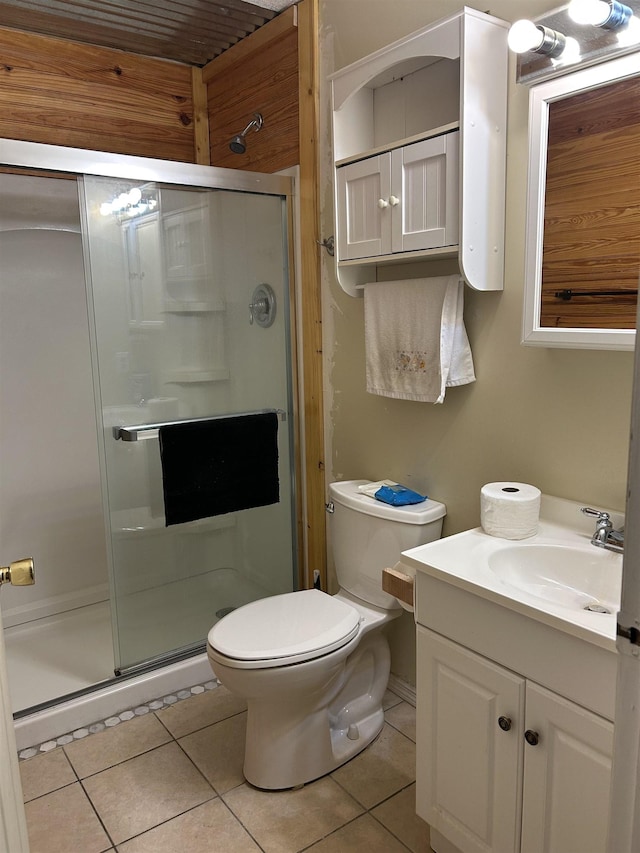 bathroom featuring tile patterned flooring, vanity, a shower with door, and toilet