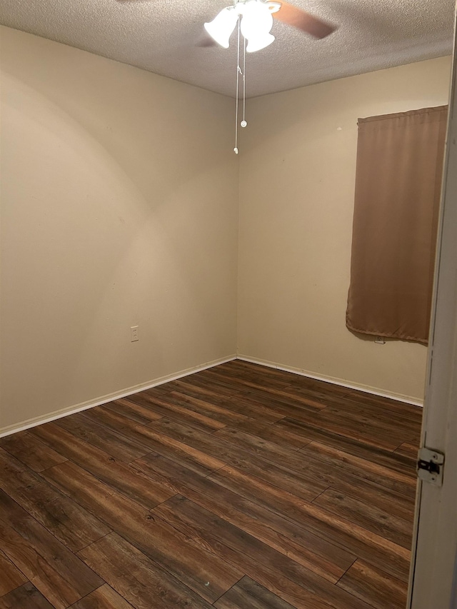 empty room with ceiling fan, dark wood-type flooring, and a textured ceiling