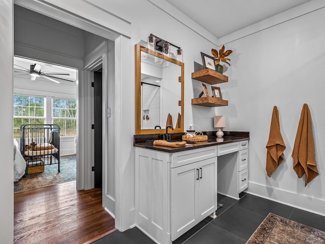 bar featuring dark hardwood / wood-style flooring, ceiling fan, and white cabinetry