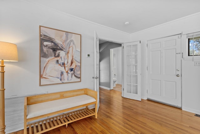 interior space with ornamental molding and light hardwood / wood-style floors