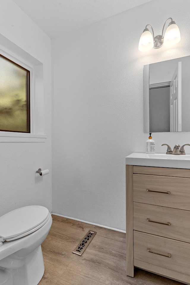 bathroom featuring wood-type flooring, vanity, and toilet