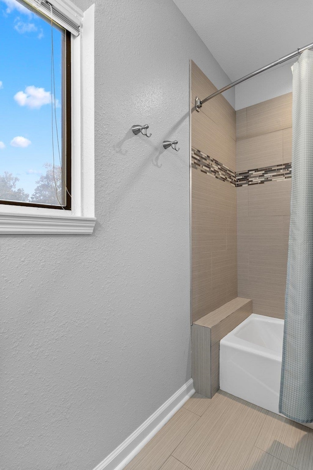 bathroom featuring tile patterned flooring, a wealth of natural light, and shower / tub combo