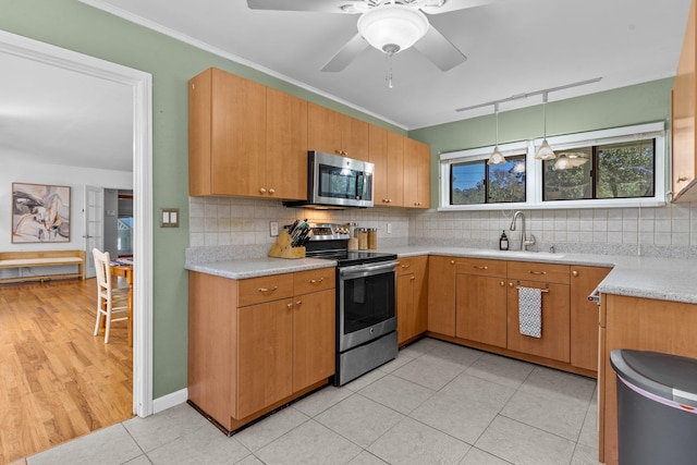 kitchen with stainless steel appliances, decorative backsplash, hanging light fixtures, sink, and light tile patterned floors