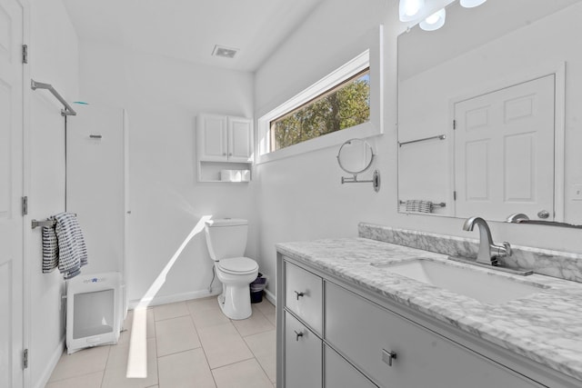 bathroom with tile patterned flooring, vanity, and toilet